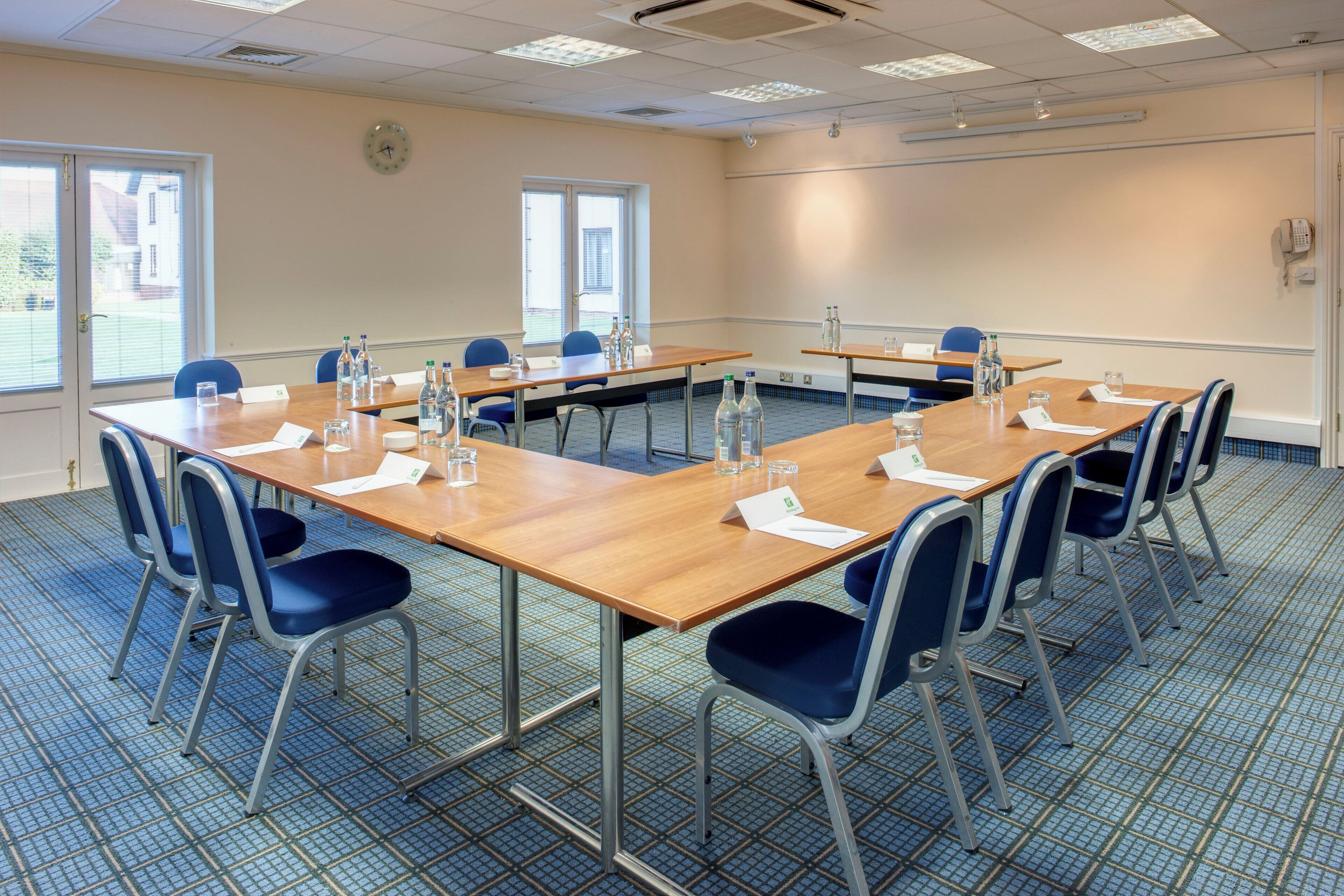 A conference room with a long table, chairs, and water bottles.