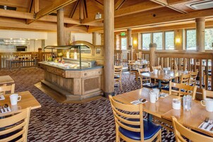 Ein Restaurant mit Holzvertäfelung, einer Buffettheke und Esstischen mit Stühlen.