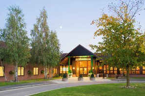 A Holiday Inn hotel with a brick facade, large windows, and a welcoming entrance.