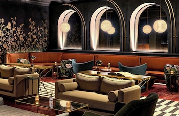 A multi-story hotel with a balcony, arched windows, and flags. at Omni Royal Orleans Hotel