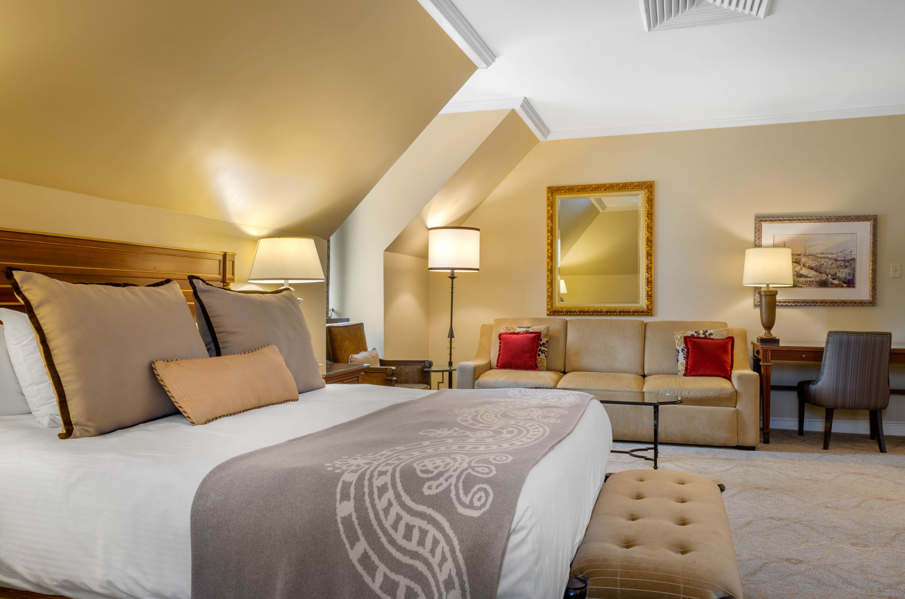 Une chambre d’hôtel avec un grand lit, un canapé, un bureau et une chaise.