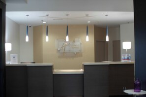 A reception area with a counter, a sign for Holiday Inn Express, and pendant lighting. - Holiday Inn Express Hickory-Hickory Mart by IHG (Hickory)