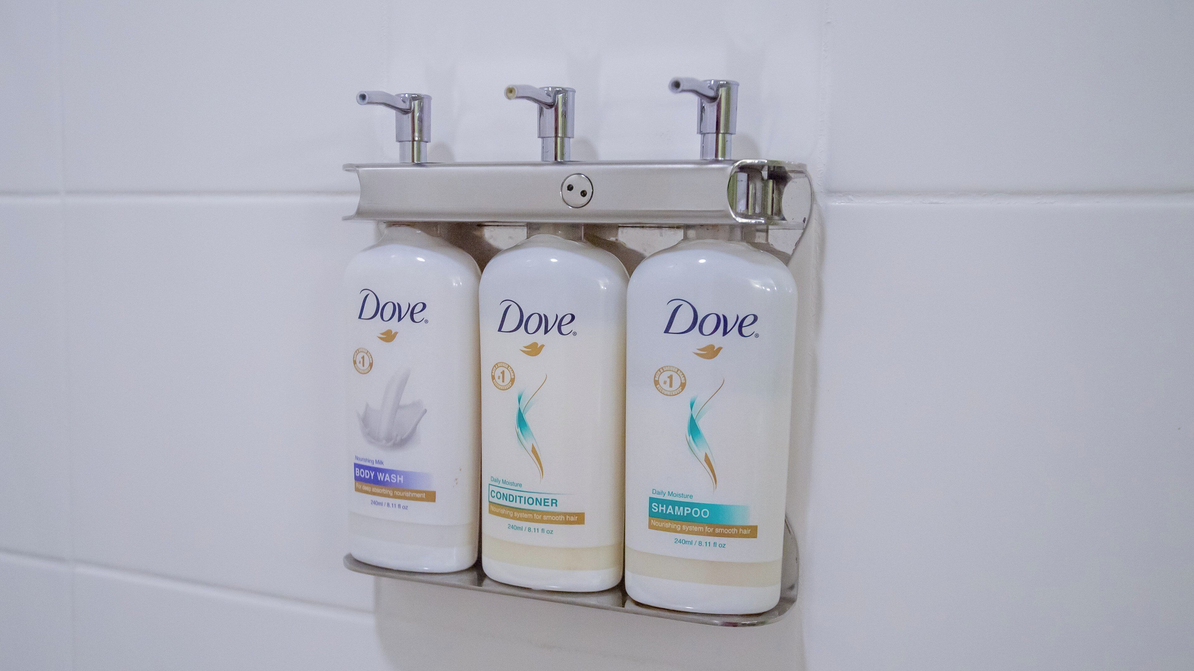 Three Dove personal care products mounted on a wall.
