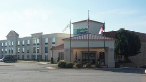 A Holiday Inn Express hotel with a modern design, featuring a prominent entrance and flags.