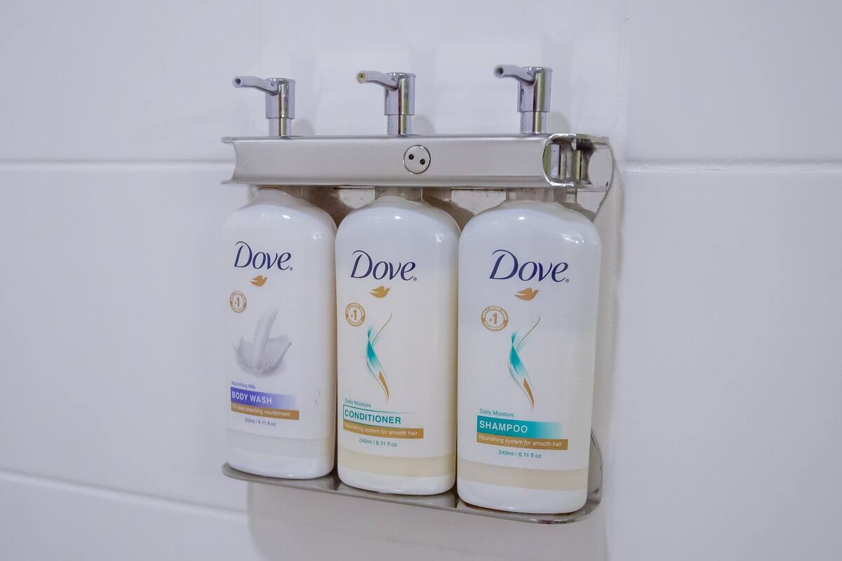 Three Dove body wash bottles mounted on a wall.