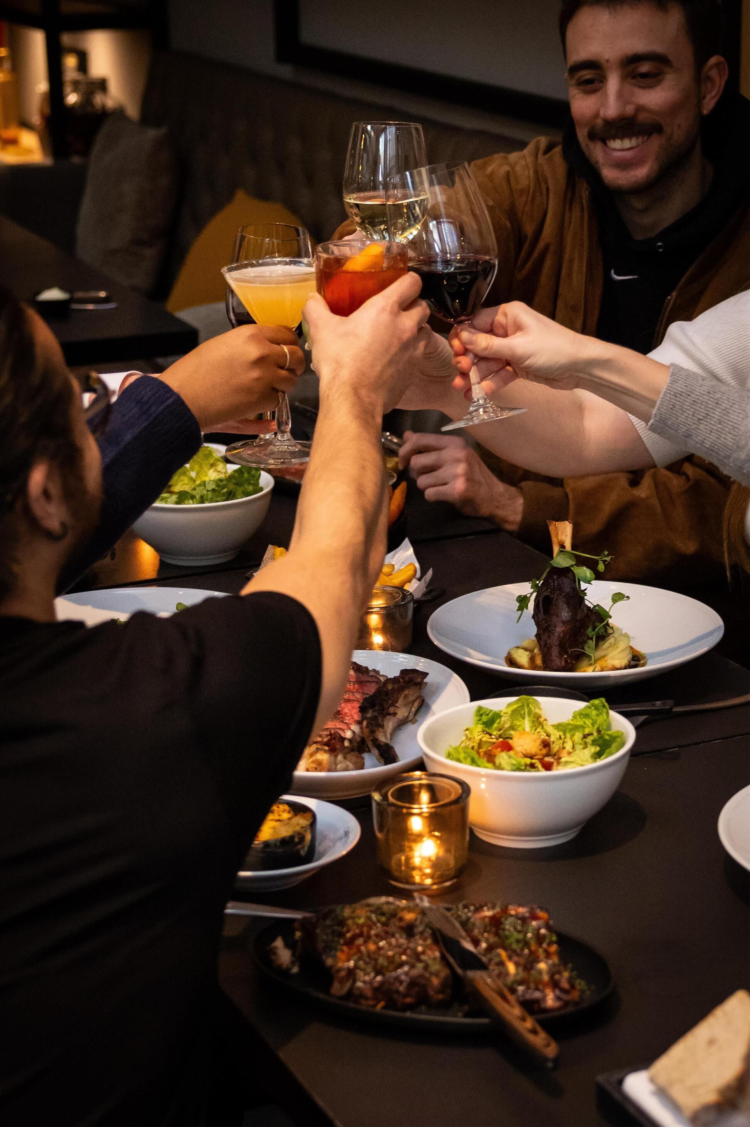 A dining table with various dishes, glasses of wine, and a candle.