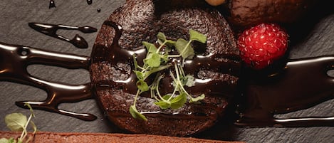 Postre de chocolate, helado y nueces sobre una superficie de pizarra.