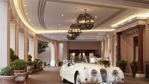 A classic white convertible car parked in a luxurious hotel lobby with ornate ceiling design and potted plants. - Mount Nelson, A Belmond Hotel, Cape Town (Cape Town)