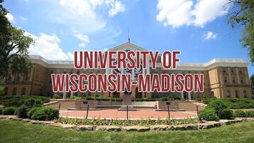 Edificio de la Universidad de Wisconsin-Madison con una fuente central y follaje circundante.