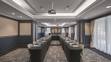 A conference room with a long table, chairs, and a projector.