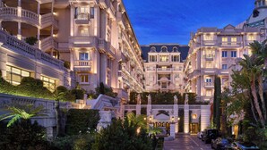 A grand hotel with multiple balconies, a central courtyard, and classical architecture. - Hôtel Métropole Monte Carlo – Spa Guerlain (Monaco)