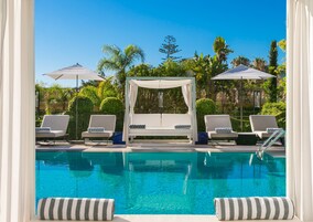 Una piscina al aire libre de temporada, sombrillas