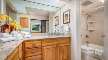 A modern bathroom with a vanity, sink, and shower.