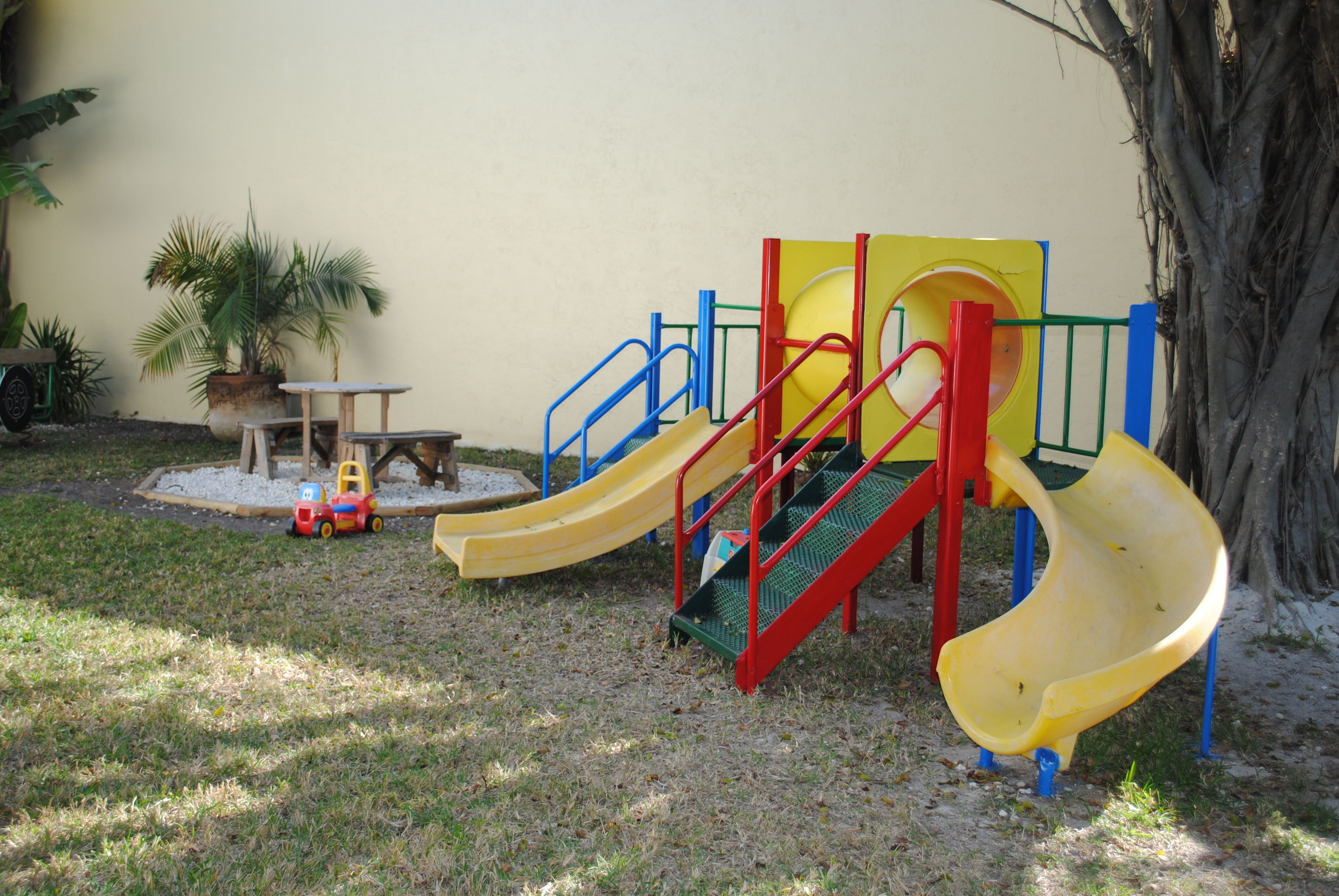 Un parque infantil con toboganes y una pequeña mesa.