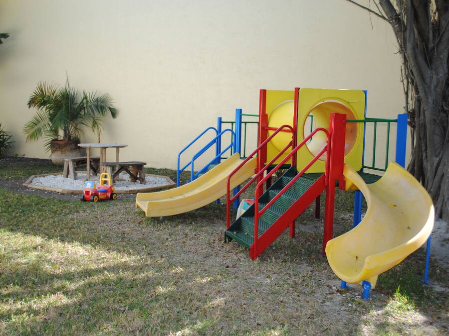 Un parque infantil con toboganes y una pequeña mesa.
