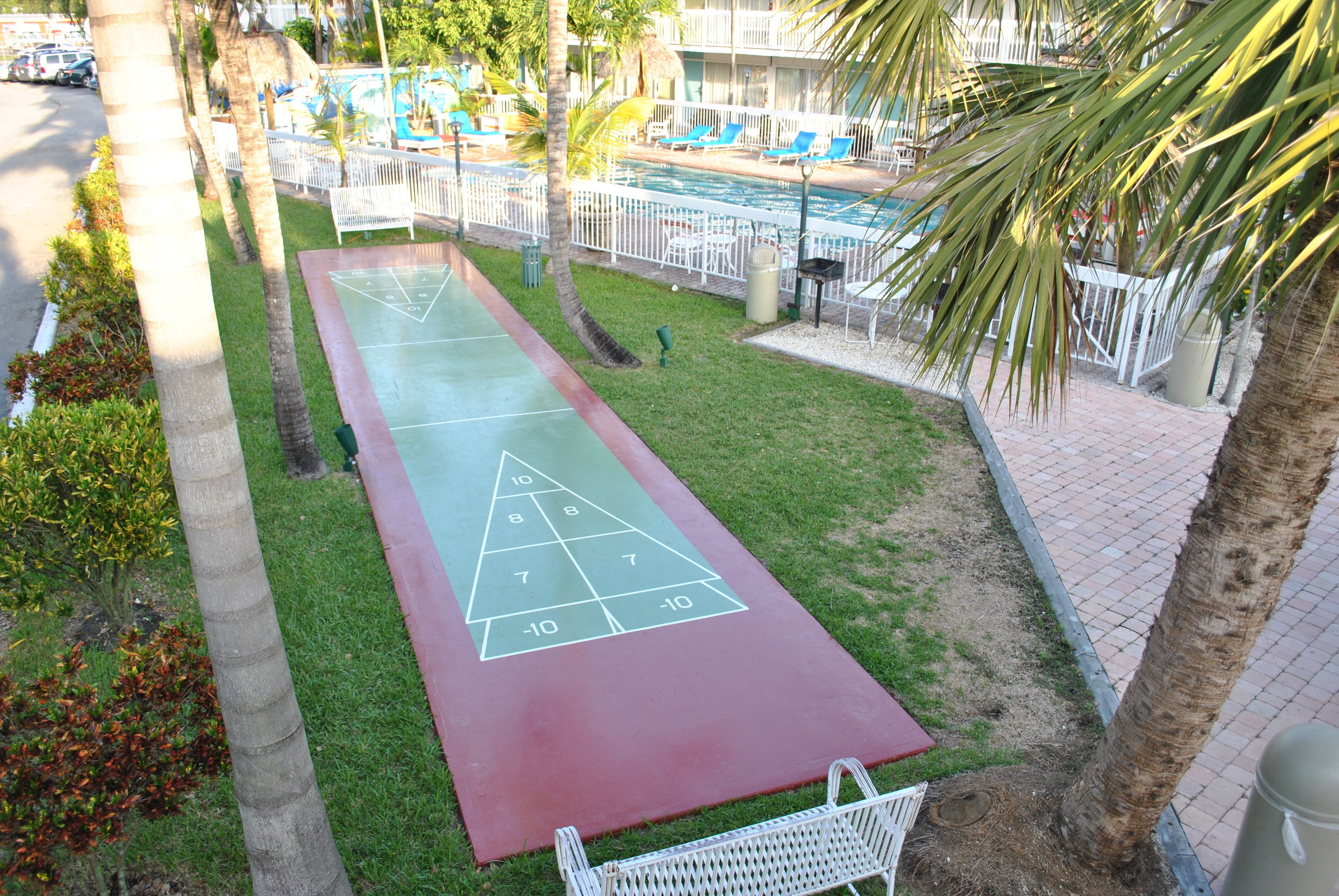 Uma quadra de bocha com área de piscina ao fundo.