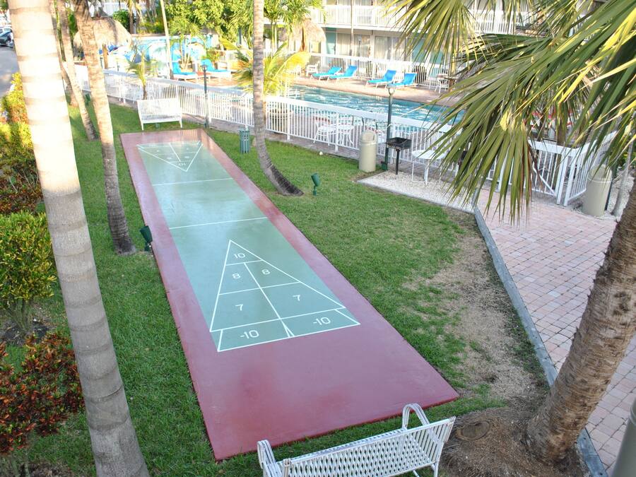 Uma quadra de bocha com área de piscina ao fundo.