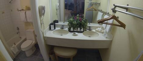 A bathroom with two sinks, a toilet, a shower, and a mirror.