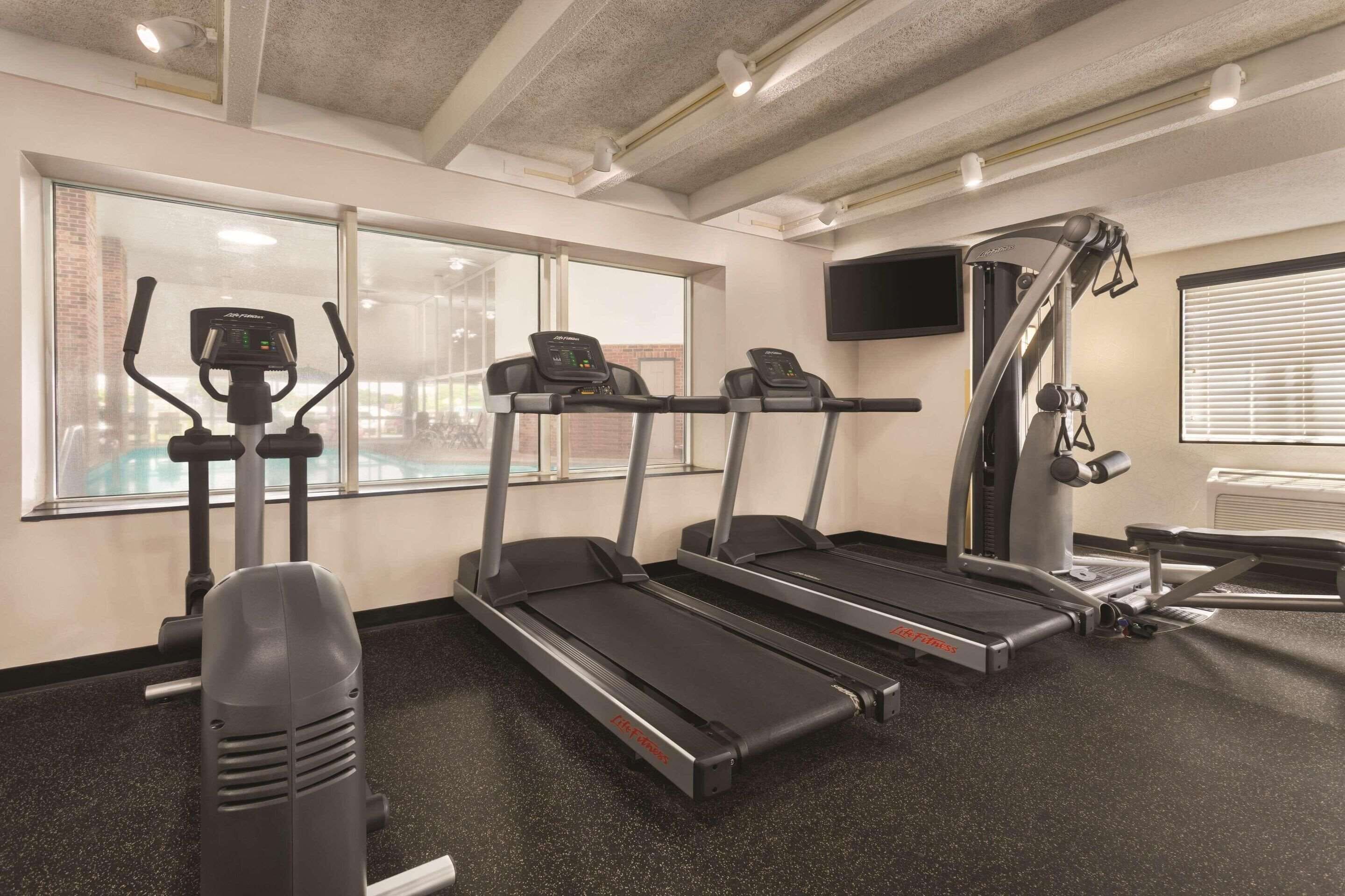 A gym with treadmills, an elliptical, and a weight machine.
