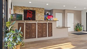 A reception area with a Red Roof sign, a fish tank, and a potted plant. - Red Roof Inn Baldwin (Jacksonville)