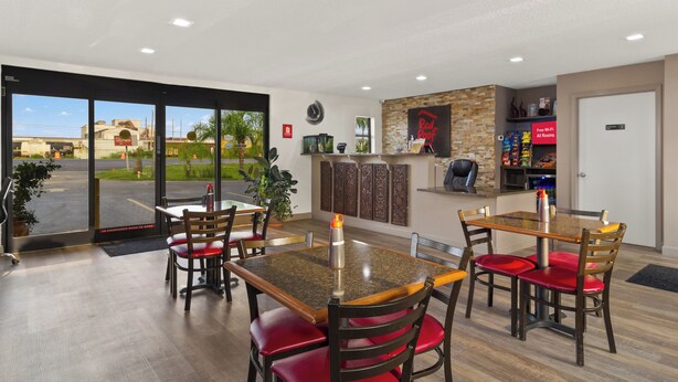 A restaurant with a modern interior, featuring a bar area, a clock, and a Red Roof sign. - Red Roof Inn Baldwin (Jacksonville)