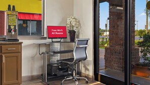 A hotel room with a desk, computer, and a view of the outside. - Red Roof Inn Baldwin (Jacksonville)