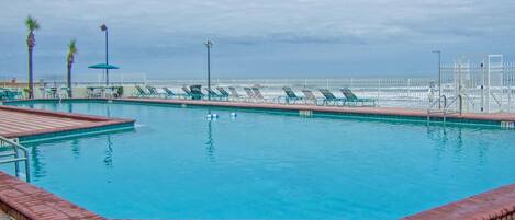 Alberca al aire libre, sombrillas en la alberca y camastros