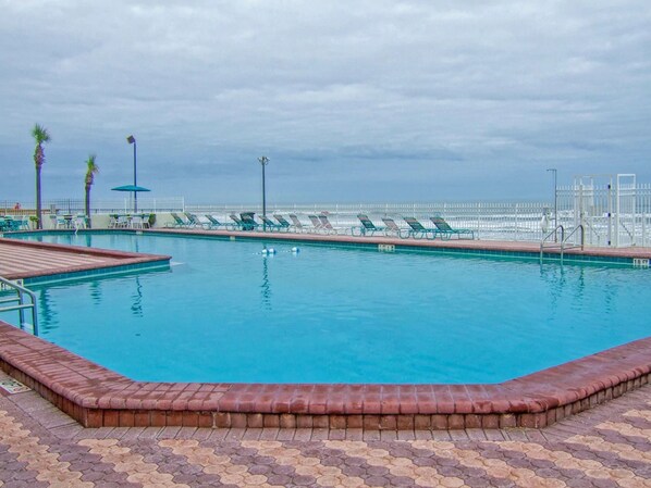 Una piscina al aire libre, sombrillas, tumbonas