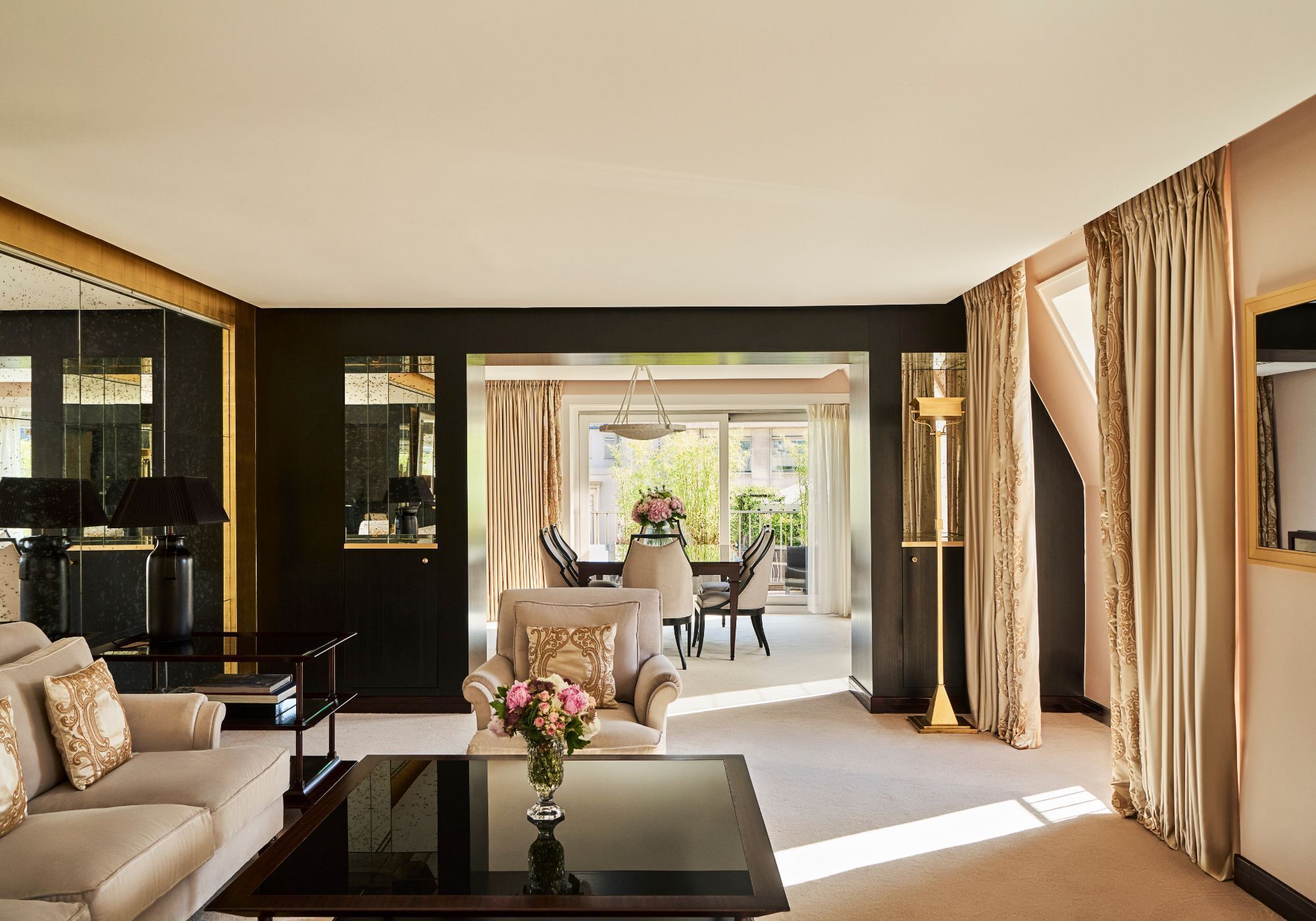 A modern living room with a sofa, coffee table, and a dining area with chairs and a table.