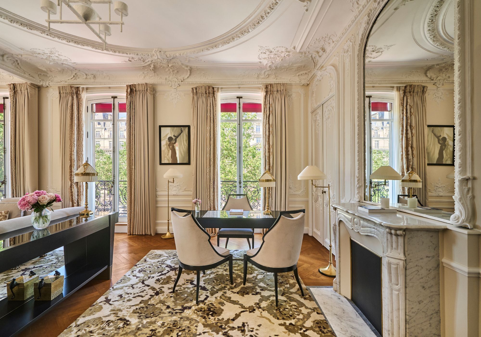 Une pièce comprenant une table à manger, des chaises, une cheminée et donnant sur l’extérieur.
