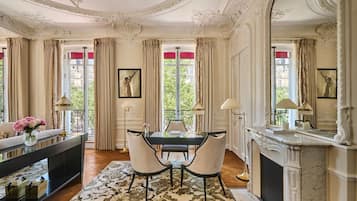 Une pièce comprenant une table à manger, des chaises, une cheminée et donnant sur l’extérieur.
