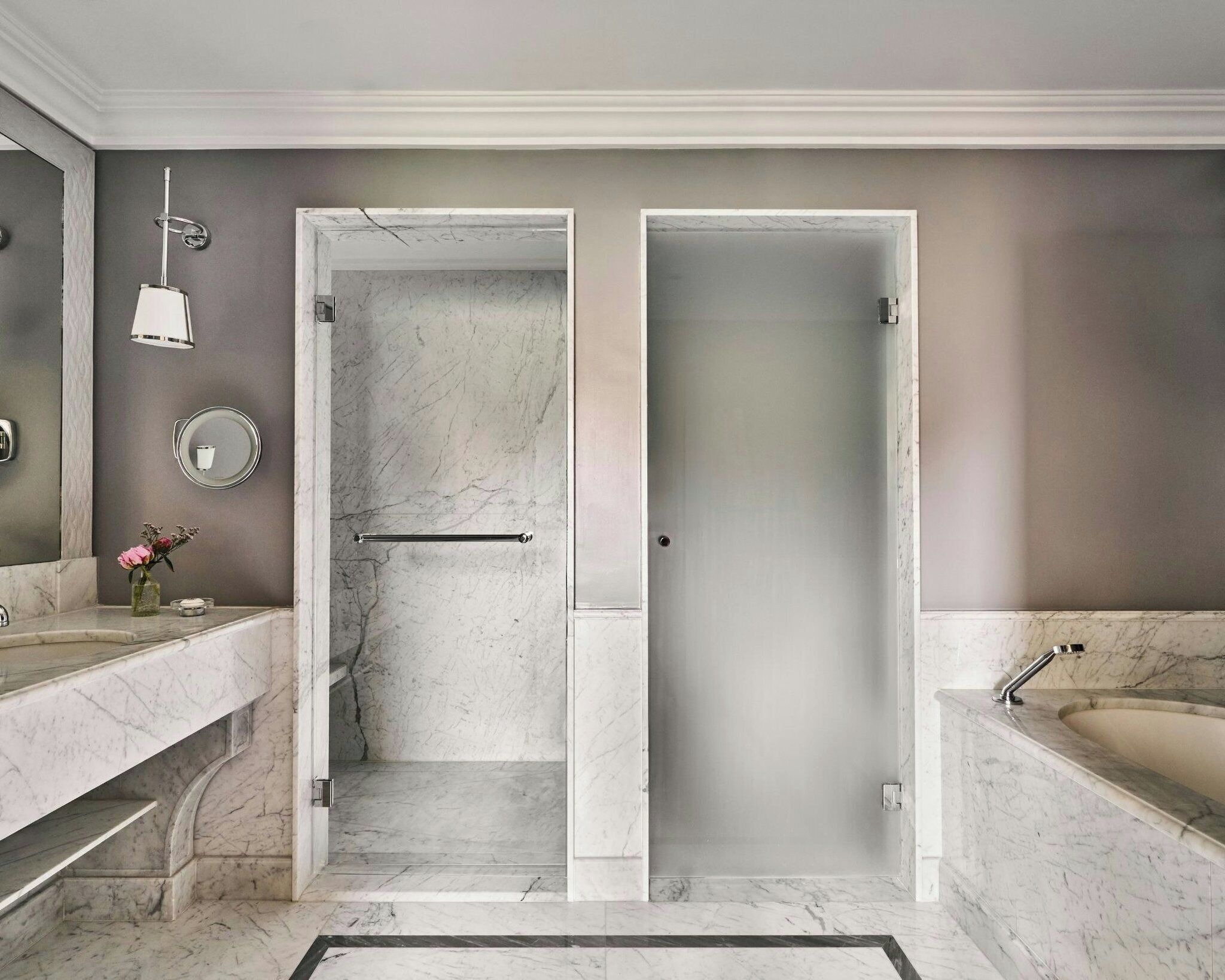A modern bathroom with two sinks, a shower, and a large mirror.