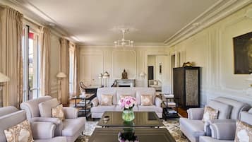 A spacious living room with a sofa set, a coffee table with a vase, and a chandelier.