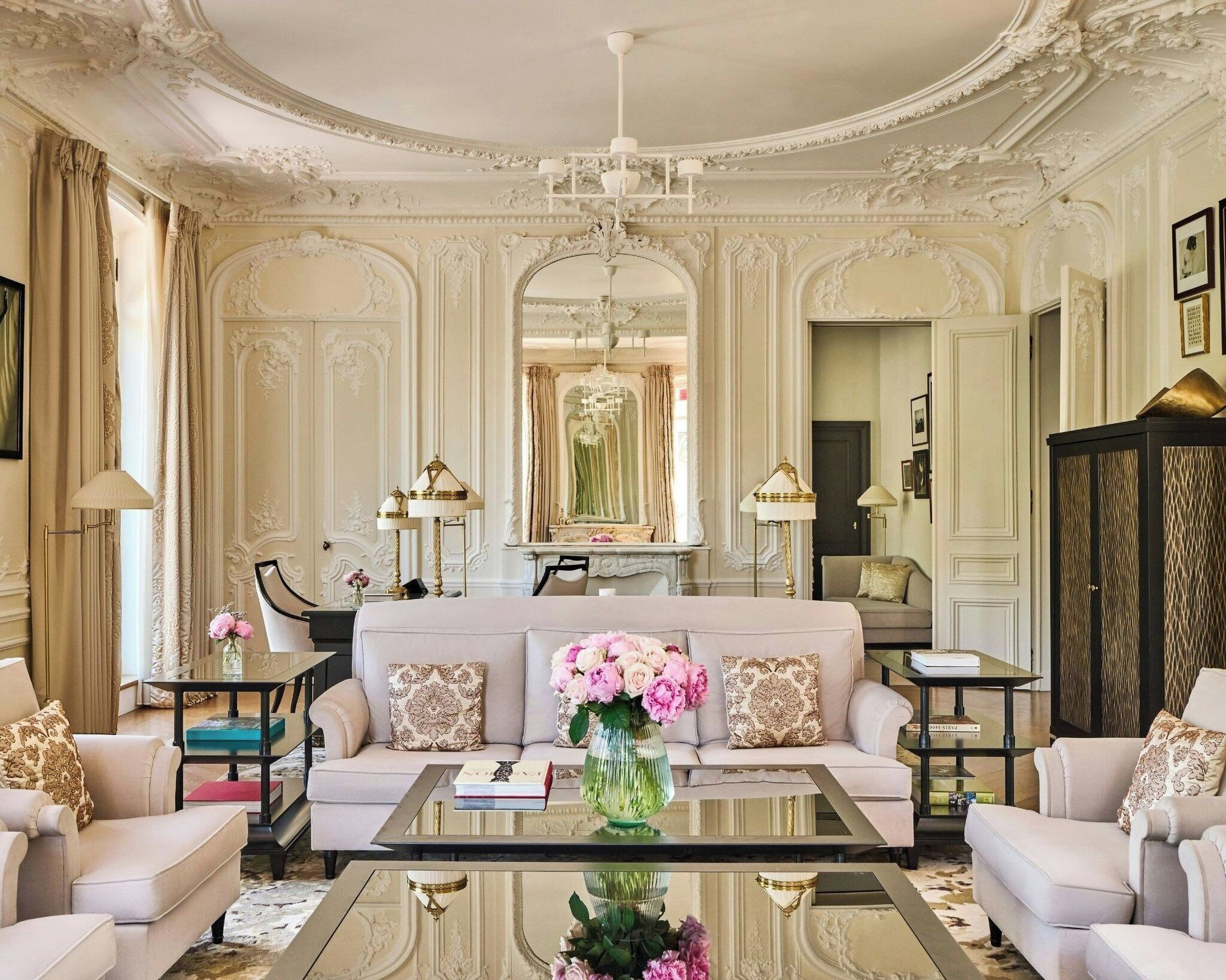 A luxurious living room with a sofa, armchairs, a coffee table, and decorative lamps.