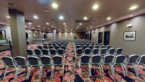 A conference room with rows of chairs, a carpeted floor, and a long table at the front. - Ashling Hotel Dublin (Dublin)