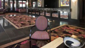 A spacious lobby with a high ceiling, a patterned carpet, a seating area with a striped chair, and artwork on the walls. - Ashling Hotel Dublin (Dublin)