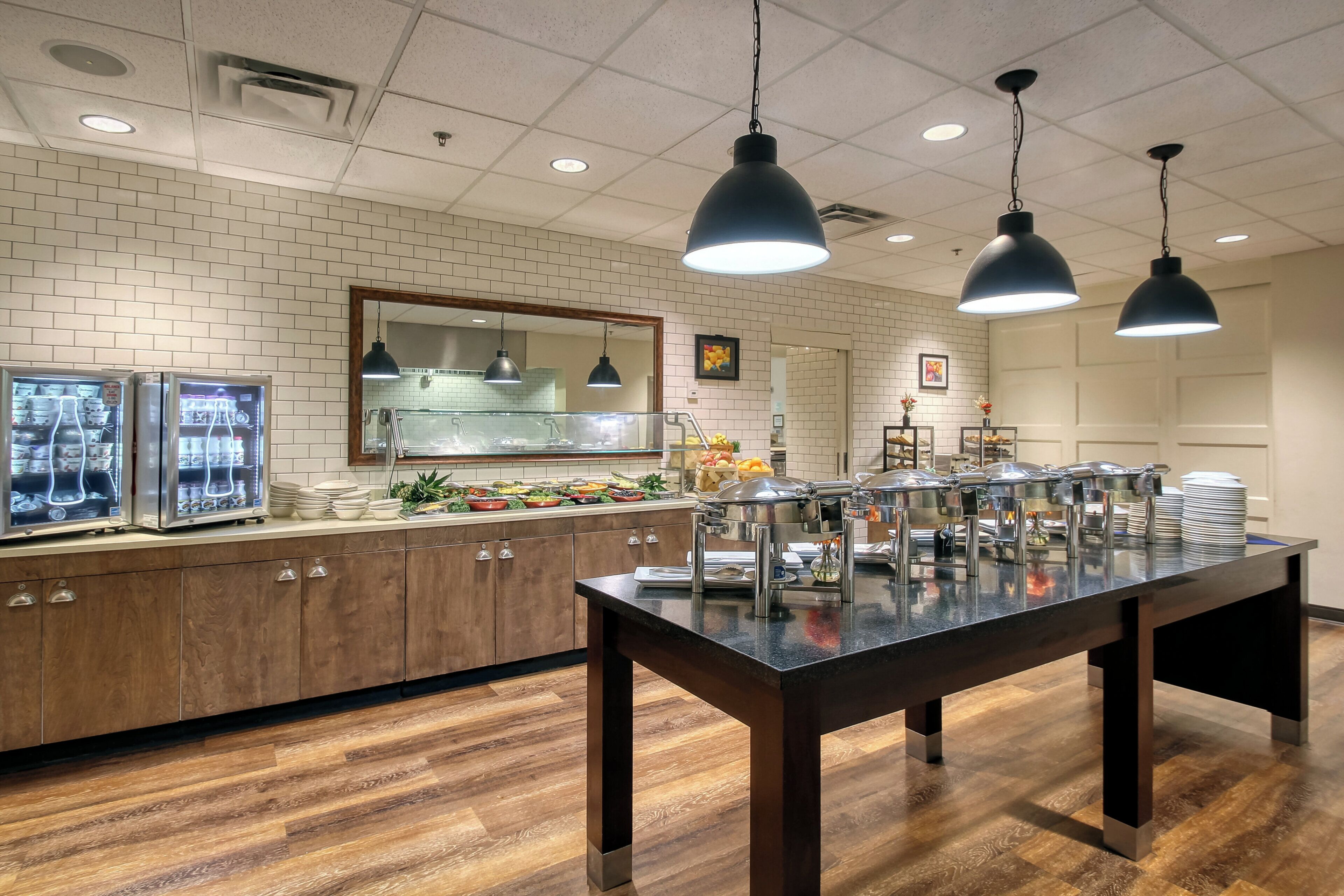 Un buffet proposant une variété de plats, un comptoir en bois et des lampes suspendues décoratives.