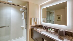 A modern bathroom with a glass shower enclosure, a vanity with a sink, and a large mirror. - Holiday Inn Hotel & Suites Atlanta Airport-North by IHG (Atlanta)