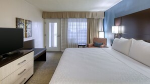 A hotel room with a large bed, a TV, a desk, and a chair. - Holiday Inn Hotel & Suites Atlanta Airport-North by IHG (Atlanta)