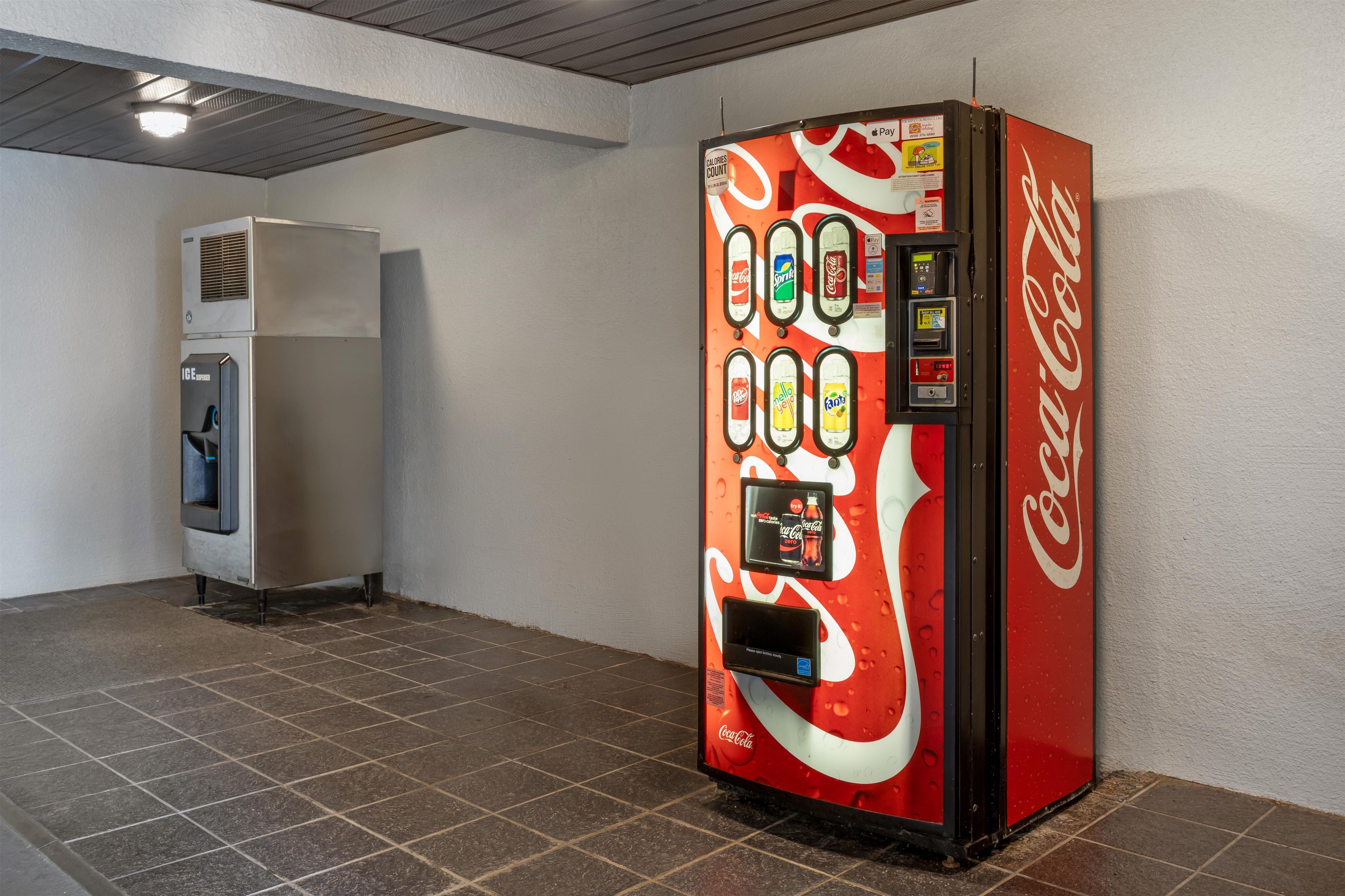 A vending machine with a Coca-Cola logo, a water dispenser, and a digital payment terminal.