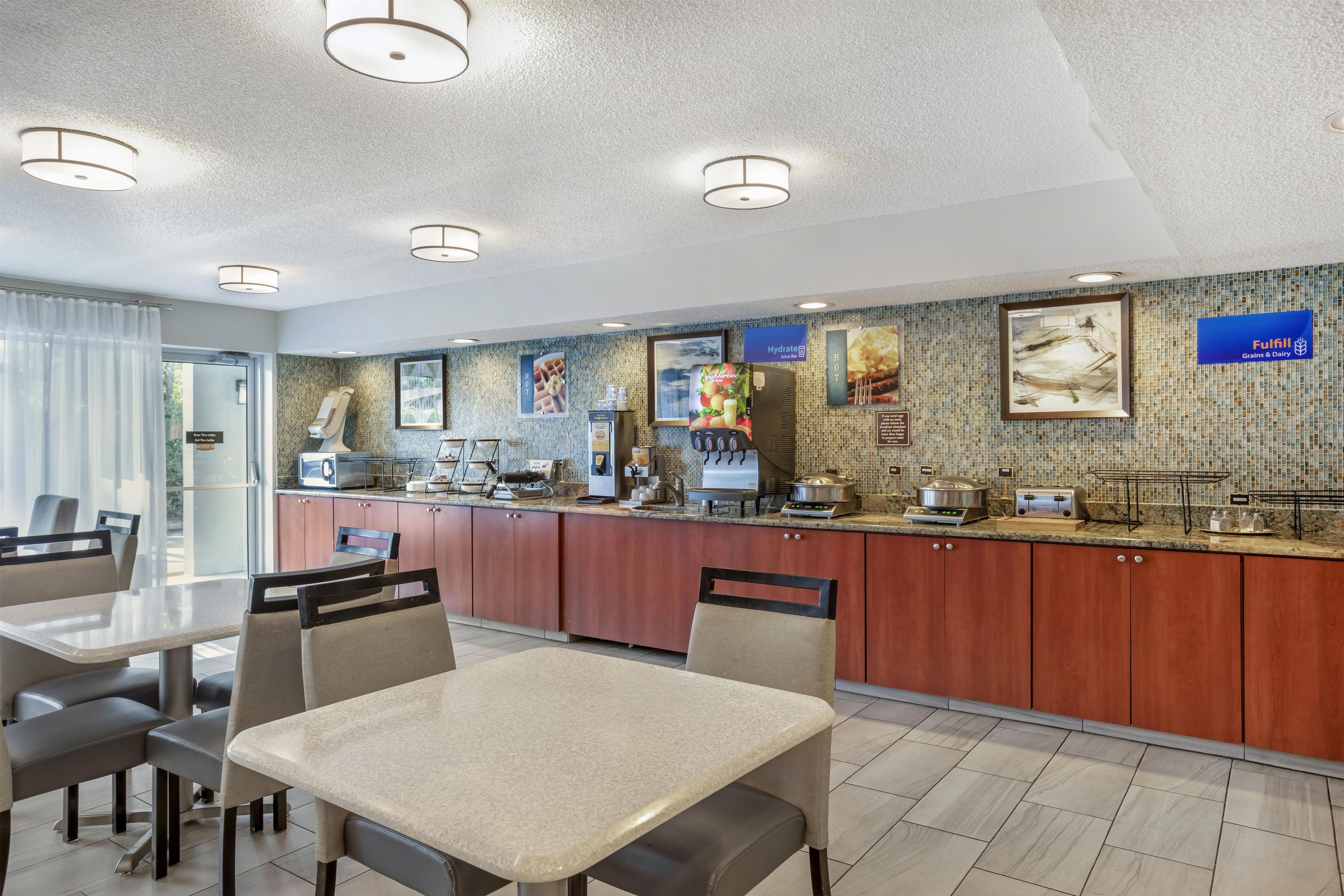 A hotel kitchen with a buffet setup, including a self-service station, a coffee machine, and a juice bar.