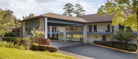 A motel with a central courtyard, multiple balconies, and a parking lot.