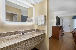 A bathroom with a granite sink, a mirror, and a towel rack. - Best Western Tallahassee-Downtown Inn & Suites (Tallahassee)