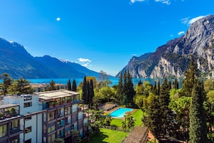 Un hotel moderno con piscina, rodeado de exuberante vegetación y montañas.