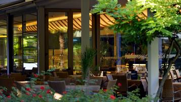An outdoor seating area with wicker furniture, glass doors, and a view of the interior.