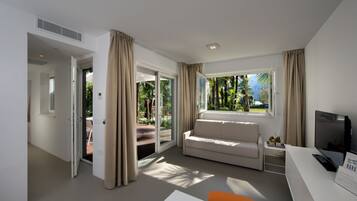 Quarto de hotel moderno com sofá, televisão e escrivaninha.