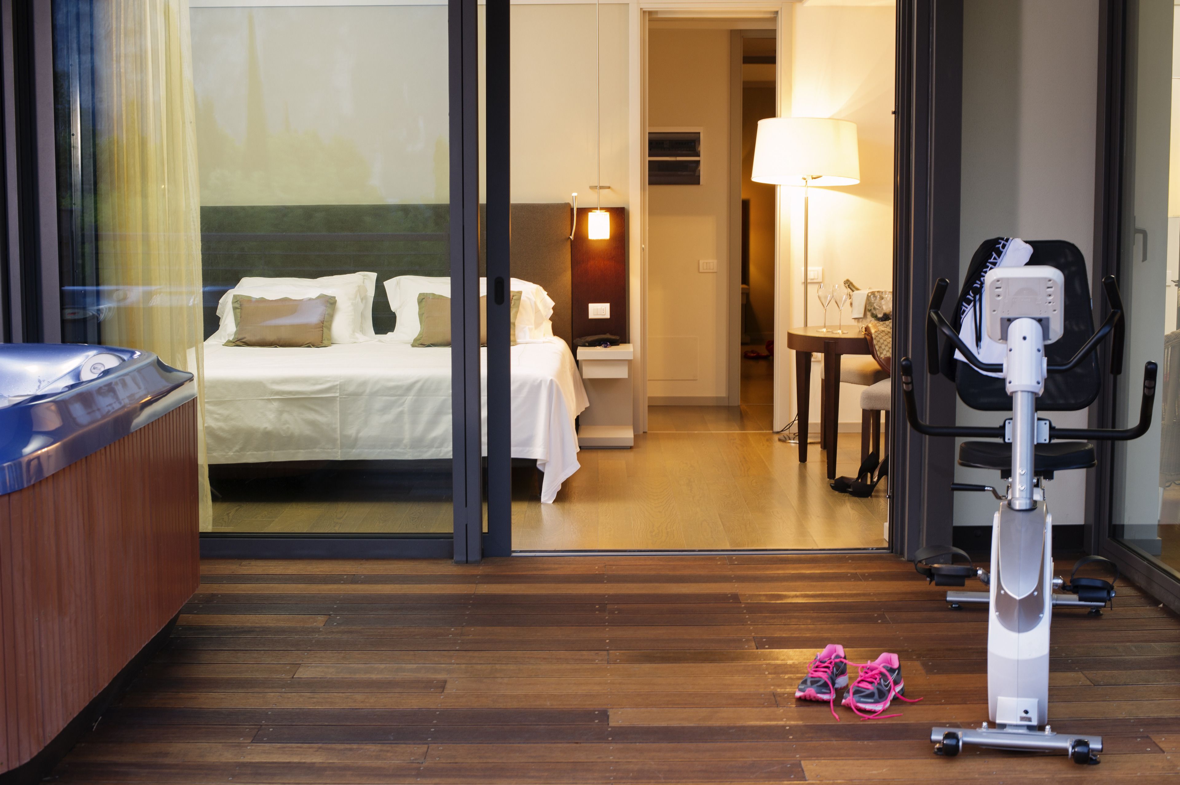 A hotel room with a bed, a massage chair, and a pair of sneakers on the floor.