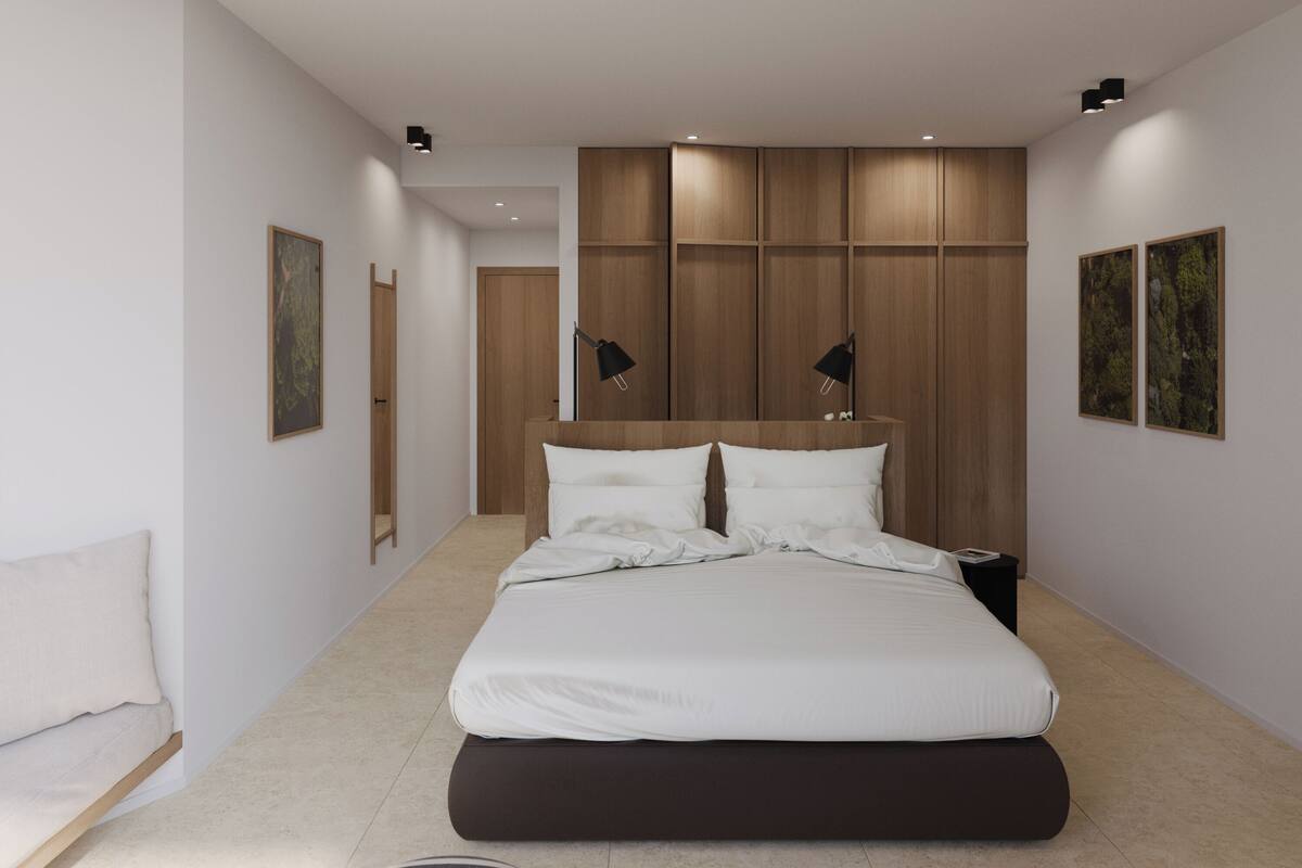 A modern bedroom with a large bed, a bedside table, a nightstand, a floor lamp, and a mirror.