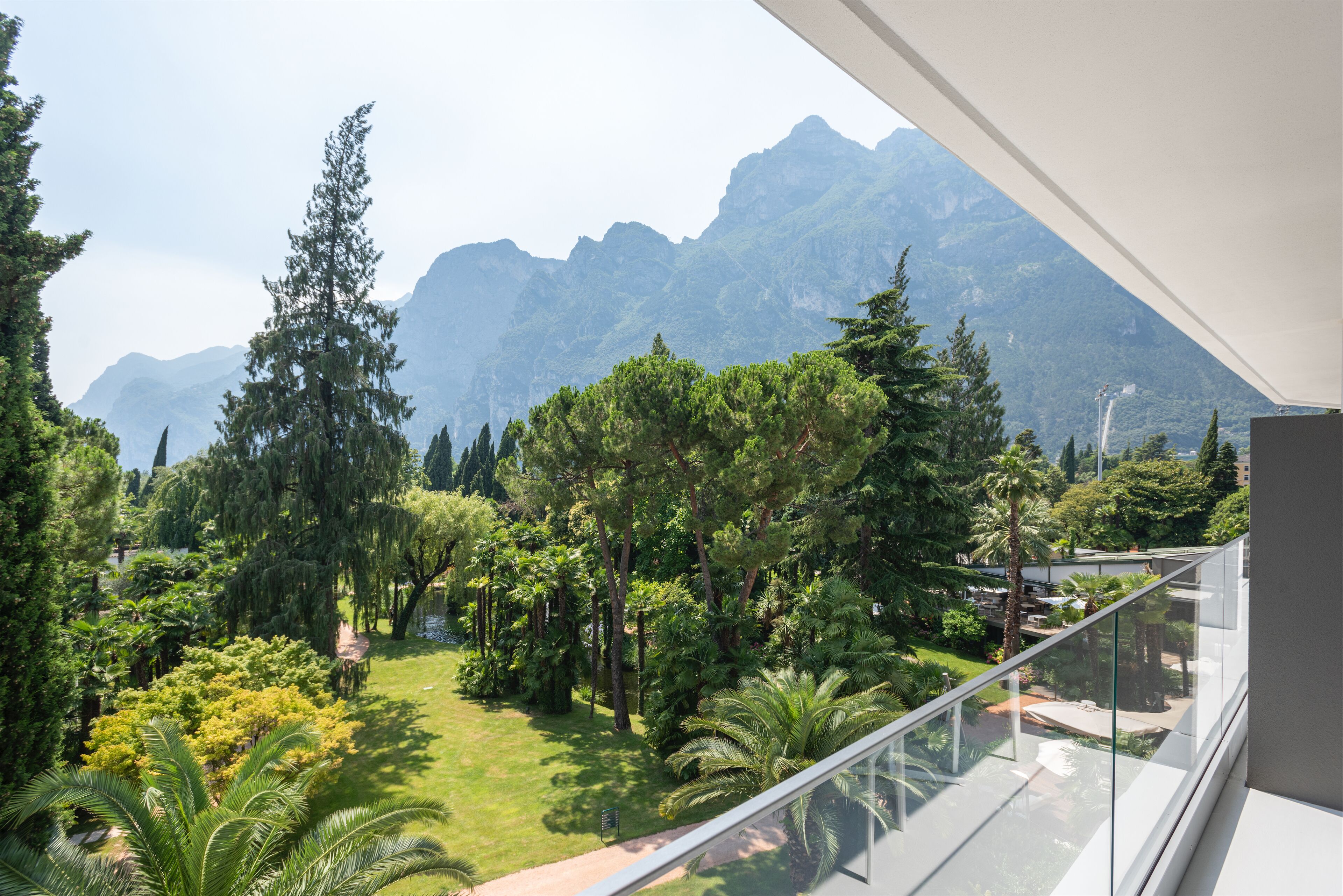 Ein Balkon mit Blick auf einen üppigen Garten und Berge.