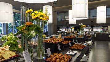 Ein Buffet mit verschiedenen Speisen und floralen Tischdekorationen.